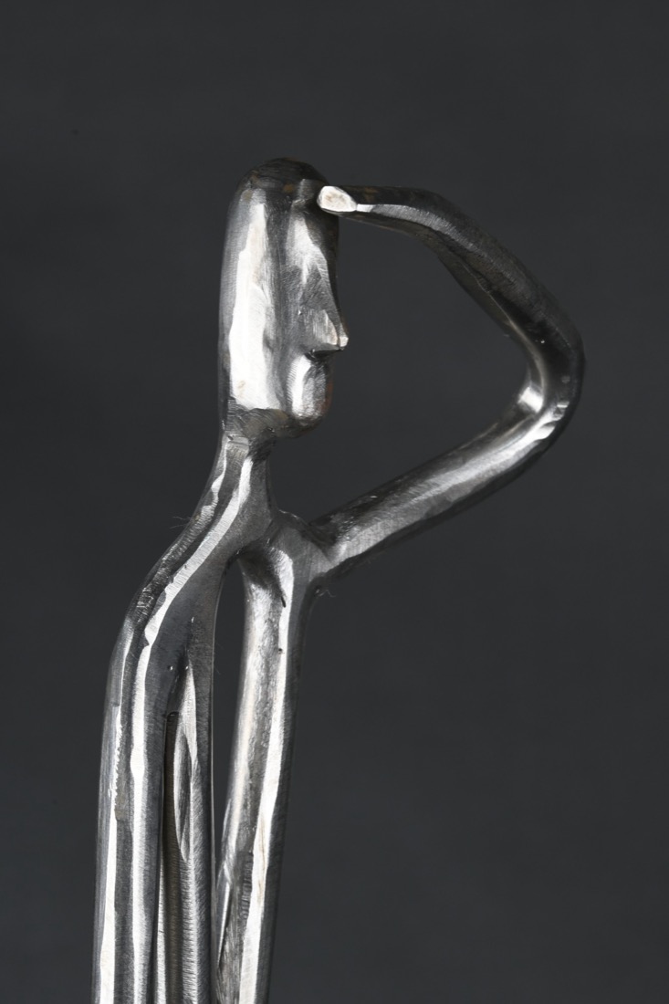 Steel sculpture by Elio Haddad: a figure shielding its eyes, looking forward