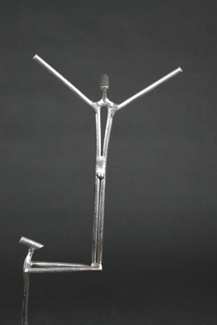 Steel sculpture by Elio Haddad: a figure reaching upward with open arms
